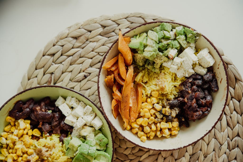 Top view of vegetarian bowls with avocado, corn, beans, and cheese for a delicious meal.